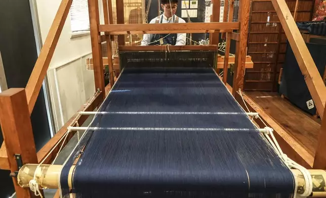 A weaver operates a handloom at Momotaro Jeans in Kojima, Okayama prefecture, western Japan, on Sept. 4, 2024. (AP Photo/Ayaka McGill)