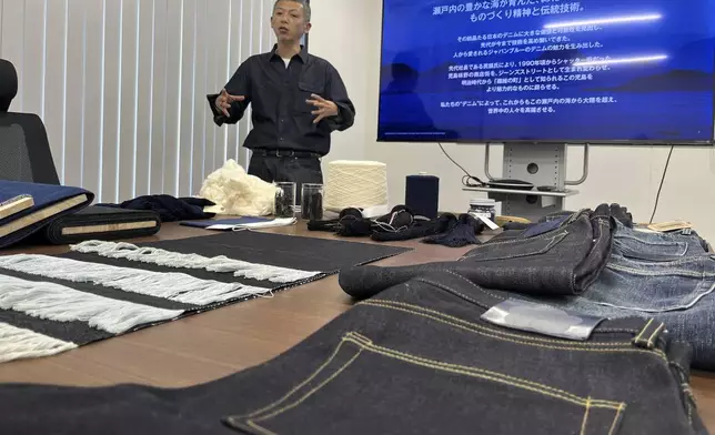 Japan Blue Co. President and Chief Operating Officer Masataka Suzuki shows some of the jeans products from Momotaro Jeans at headquarters in Kojima, southwestern Japan. Taken Sept. 4, 2024. (AP Photo/Yuri Kageyama)