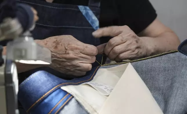 Naomi Takebayashi, a seamstress at Momotaro Jeans, hand-stiches a pair of jeans in Kojima, Okayama prefecture, western Japan, on Sept. 4, 2024. (AP Photo/Ayaka McGill)