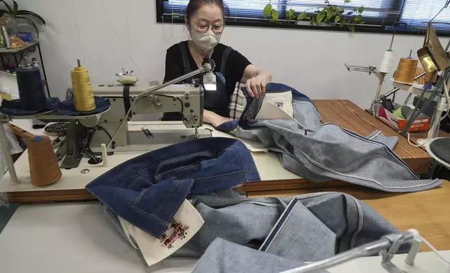 Naomi Takebayashi, a seamstress at Momotaro Jeans, works on pairs of jeans in Kojima, Okayama prefecture, western Japan, on Sept. 4, 2024. (AP Photo/Ayaka McGill)