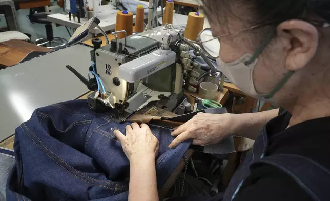 Naomi Takebayashi, a seamstress at Momotaro Jeans, sewing a pair of jeans in Kojima, Okayama prefecture, western Japan, on Sept. 4, 2024. (AP Photo/Ayaka McGill)