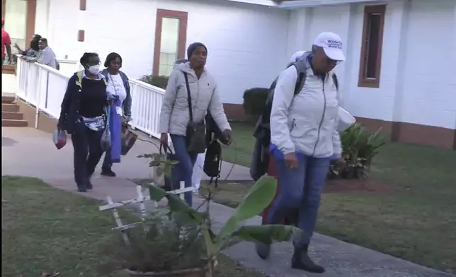 Festival goers who attended a Gullah Geechee festival on Sapelo Island leave the Elm Grove Church where they were taken to reunite with loved ones on Sapelo Island, Ga in McIntosh county, Sunday, Oct. 20, 2024. (AP Photo/Lewis M. Levine)