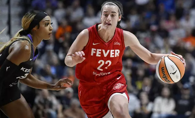 Indiana Fever guard Caitlin Clark (22) drives to the basket as Connecticut Sun guard DiJonai Carrington defends during a first-round WNBA basketball playoff game, Wednesday, Sept. 25, 2024, in Uncasville, Conn. (AP Photo/Jessica Hill)