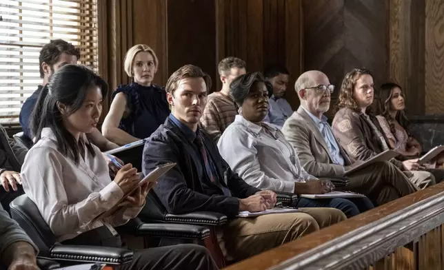 This image released by Warner Bros. Entertainment shows Leslie Bibb, top center, Chikako Fukuyama, from bottom left, Nicholas Hoult, Adrienne C. Moore, J.K. Simmons, Drew Scheid, and Hedy Nasser in a scene from "Juror #2". (Warner Bros. Entertainment via AP)