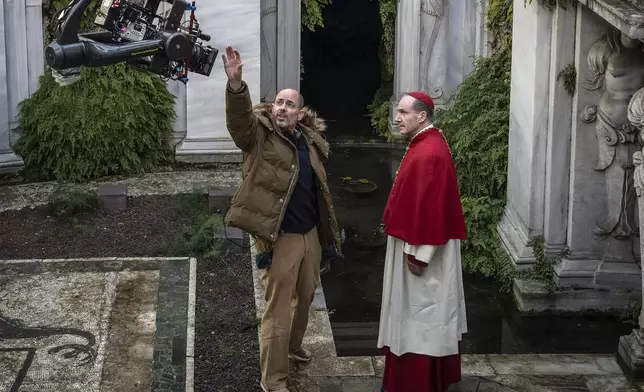 This image released by Focus features shows director Edward Berger, left, and actor Ralph Fiennes on the set of "Conclave." (Philippe Antonello/Focus Features via AP)