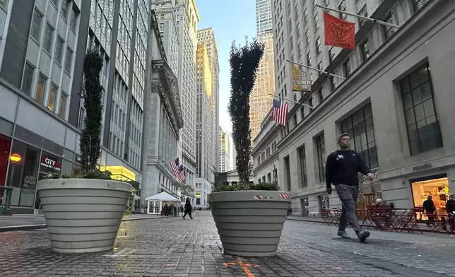 FILE - People pass the New York Stock Exchange, at rear, in New York's Financial District on Oct. 16, 2024. (AP Photo/Peter Morgan, File)