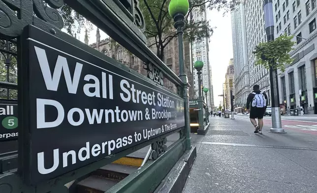 FILE - People pass the entrance for the Wall Street subway station on Sept. 2, 2024, in New York. (AP Photo/Peter Morgan, File)