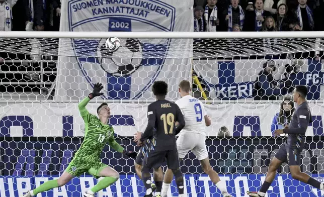 Fredrik Jensen of Finland, centre right, fails to score past goalkeeper Dean Henderson of England during the UEFA Nations League soccer match between Finland and England, at the Olympic Stadium in Helsinki, Finland, Sunday, Oct. 13, 2024. (Antti Aimo-Koivisto/Lehtikuva via AP)