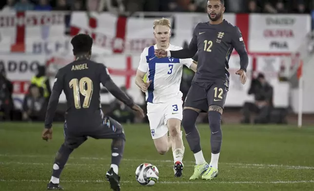 England's Angel Gomes, left, and Kyle Walker, right, challenge for the ball with Matti Peltola of Finland during the UEFA Nations League soccer match between Finland and England, at the Olympic Stadium in Helsinki, Finland, Sunday, Oct. 13, 2024. (Antti Aimo-Koivisto/Lehtikuva via AP)