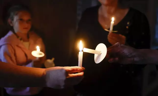 FILE - Pastor Carrie Bland, hand at left, uses her candle to light others during a candlelight vigil for the victims of the mass shooting a day before in Fall City, Wash., Tuesday, Oct. 22, 2024. (Jennifer Buchanan/The Seattle Times via AP, File)