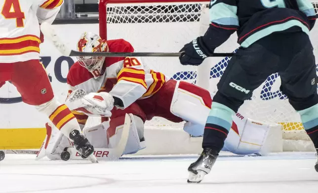 Calgary Flames goalie Dan Vladar makes a save during the third period of an NHL hockey game against the Seattle Kraken, Saturday, Oct. 19, 2024, in Seattle. (AP Photo/Stephen Brashear)