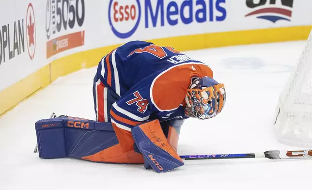 Edmonton Oilers goalie Stuart Skinner (74) goes down after being slashed by the Calgary Flames during first-period NHL hockey game action in Edmonton, Alberta, Sunday, Oct. 13, 2024. (Jason Franson/The Canadian Press via AP)