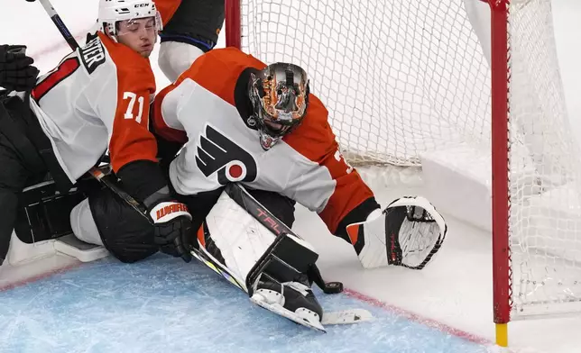 Philadelphia Flyers goaltender Samuel Ersson looks down at the puck on a save against the Boston Bruins during the third period of an NHL hockey game, Tuesday, Oct. 29, 2024, in Foxborough, Mass. (AP Photo/Charles Krupa)