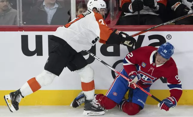 Montreal Canadiens Patrik Laine (92) is checked by Philadelphia Flyers Louie Belpedio (37) during the third period of an NHL preseason hockey game in Montreal on Monday, Sept. 23, 2024. (Ryan Remiorz/The Canadian Press via AP)