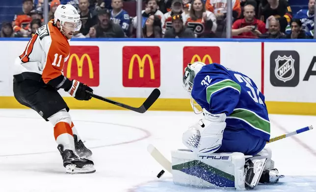 Vancouver Canucks goaltender Kevin Lankinen (32) stops Philadelphia Flyers' Travis Konecny (11) during the first period of an NHL hockey game in Vancouver, British Columbia, Friday, Oct. 11, 2024. (Ethan Cairns/The Canadian Press via AP)