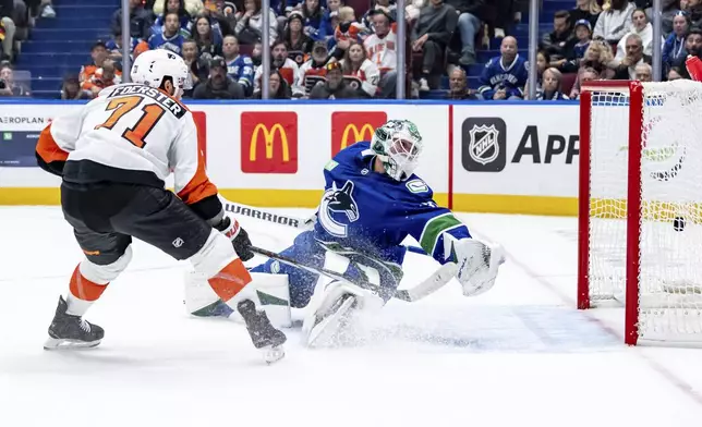 Philadelphia Flyers' Tyson Foerster (71) scores against Vancouver Canucks' goaltender Kevin Lankinen (32) during the first period of an NHL hockey game in Vancouver, British Columbia, Friday, Oct. 11, 2024. (Ethan Cairns/The Canadian Press via AP)