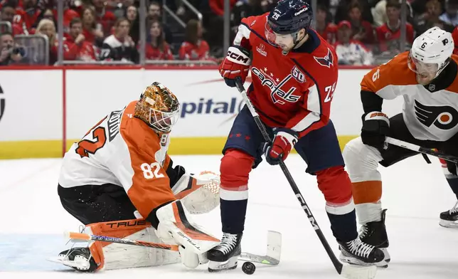 Washington Capitals center Hendrix Lapierre (29) battles for the puck against Philadelphia Flyers goaltender Ivan Fedotov (82) and defenseman Travis Sanheim (6) during the first period of an NHL hockey game, Wednesday, Oct. 23, 2024, in Washington. (AP Photo/Nick Wass)