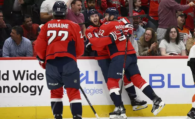 Washington Capitals right wing Taylor Raddysh (16) celebrates his goal with defenseman Dylan McIlrath (52) and right wing Brandon Duhaime (22) during the first period of an NHL hockey game against the Philadelphia Flyers, Wednesday, Oct. 23, 2024, in Washington. (AP Photo/Nick Wass)