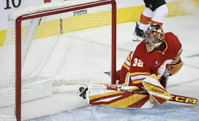 Calgary Flames goalie Dustin Wolf looks back as the Philadelphia Flyers score during the second period of an NHL hockey game in Calgary, Alberta, Saturday, Oct. 12, 2024. (Jeff McIntosh/The Canadian Press via AP)