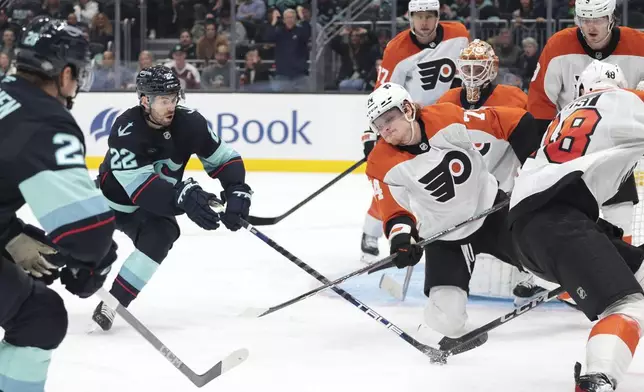 Seattle Kraken right wing Oliver Bjorkstrand (22) and Philadelphia Flyers right wing Owen Tippett, center right, compete for the puck in front of Flyers goaltender Ivan Fedotov (82) during the second period of an NHL hockey game Thursday, Oct. 17, 2024, in Seattle. (AP Photo/Jason Redmond)