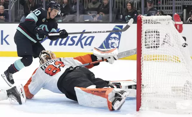 Seattle Kraken right wing Eeli Tolvanen (20) scores past diving Philadelphia Flyers goaltender Ivan Fedotov (82) during the second period of an NHL hockey game Thursday, Oct. 17, 2024, in Seattle. (AP Photo/Jason Redmond)