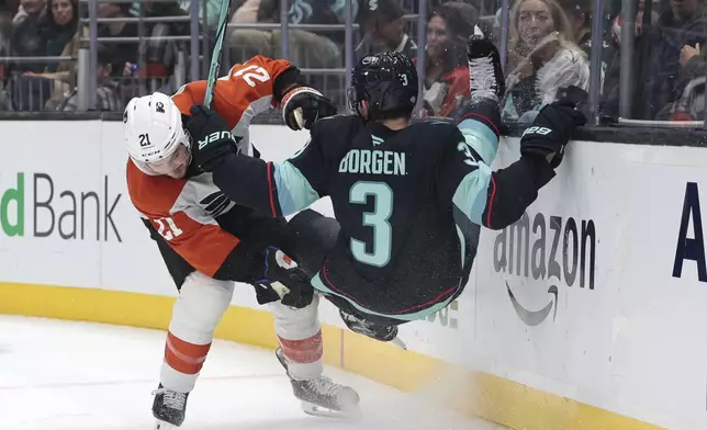 Philadelphia Flyers center Scott Laughton, left, takes Seattle Kraken defenseman Will Borgen (3) into the boards during the first period of an NHL hockey game Thursday, Oct. 17, 2024, in Seattle. (AP Photo/Jason Redmond)