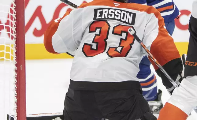 Philadelphia Flyers goalie Samuel Ersson (33) is scored on by Edmonton Oilers' Adam Henrique (19) during the second period of an NHL hockey game in Edmonton, Alberta, Tuesday, Oct. 15, 2024. (Amber Bracken/The Canadian Press via AP)