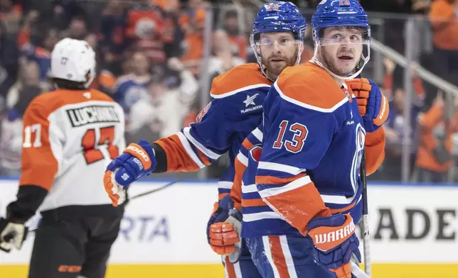 Philadelphia Flyers' Jett Luchanko (17) skates off as Edmonton Oilers' Mattias Janmark (13) and Connor Brown (28) celebrate their goal during the second period of an NHL hockey game in Edmonton, Alberta, Tuesday, Oct. 15, 2024. (Amber Bracken/The Canadian Press via AP)