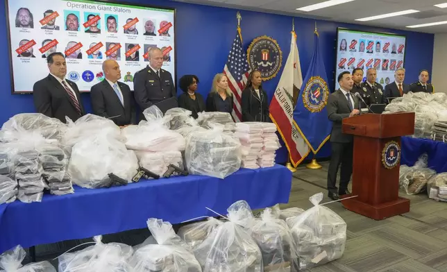 United States Attorney Martin Estrada, right at podium, joined by federal, local, and international officials, announces federal charges and arrests of alleged members of a transnational drug trafficking operation that routinely shipped hundreds of kilograms of cocaine from Colombia, through Mexico and Southern California, to Canada and other locations in the United States, during a news conference at the FBI offices in Los Angeles, Thursday, Oct. 17, 2024. (AP Photo/Damian Dovarganes)