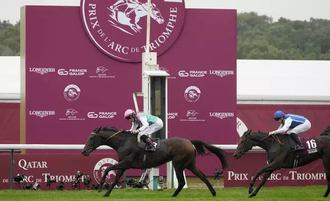 Bluestocking ridden by Rossa Ryan crosses the finish line ahead of Aventure ridden by Stephane Pasquier, right, to win the Prix de l'Arc de Triomphe horse race at the Longchamp race track, outside Paris, Sunday, Oct. 6, 2024. (AP Photo/Michel Euler)