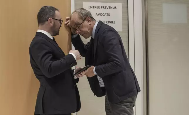 Member of the French far right party Alexandre Varaut, left, talks to an unidentified person at the court house in Paris, Monday, Sept. 30, 2024. (AP Photo/Thibault Camus)