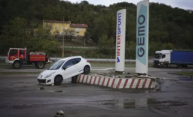 A car is seen in a parking lot of a shopping mall in Givors, central France, after torrential rains and flooding submerged roads and railways, Friday, Oct. 18, 2024. (AP Photo/Laurent Cirpiani)