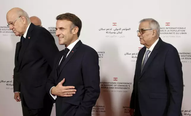 France's President Emmanuel Macron reacts next to Lebanon's Prime Minister caretaker Prime Minister Najib Mikati, left, and Lebanon's Minister of Foreign Affairs Abdallah Bou Habibas they arrive for an international press conference in support of Lebanon, in Paris, Thursday, Oct.24, 2024. (Alain Jocard, Pool via AP)