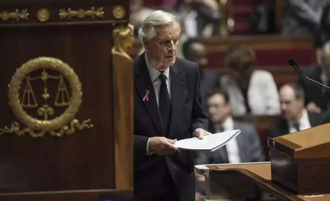 France's Prime Minister Michel Barnier arrives at stage to deliver a speech at the National Assembly, in Paris, Tuesday, Oct. 1, 2024. (AP Photo/Thibault Camus)