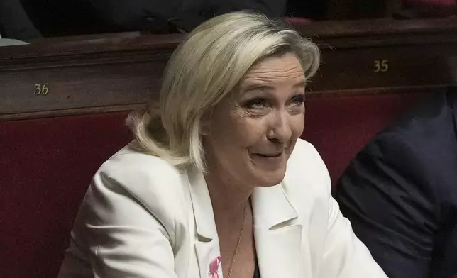 French far-right leader Marine Le Pen reacts during the speech of Prime Minister Michel Barnier at the National Assembly, in Paris, Tuesday, Oct. 1, 2024. (AP Photo/Thibault Camus)