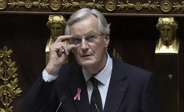 France's Prime Minister Michel Barnier adjusts his glasses as he delivers a speech at the National Assembly, in Paris, Tuesday, Oct. 1, 2024. (AP Photo/Thibault Camus)