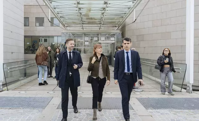 FILE - Gisele Pelicot, center, who was allegedly drugged by her now ex-husband so that she could be raped while unconscious by other men, leaves the court house, in Avignon, southern France, on Oct. 16, 2024. (AP Photo/Lewis Joly, File)