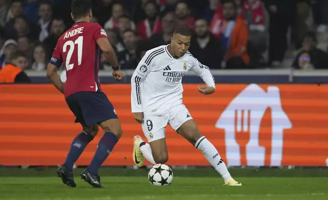 Real Madrid's Kylian Mbappe, right, dribbles the ball past Lille's Benjamin Andre during the Champions League opening phase soccer match between Lille and Real Madrid at the Stade Pierre Mauroy in Villeneuve-d'Ascq, outside Lille, France, Wednesday, Oct. 2, 2024. (AP Photo/Thibault Camus)