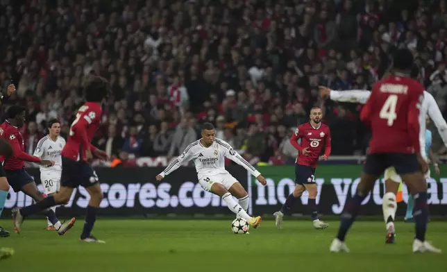 Real Madrid's Kylian Mbappe, center dribbles the ball during the Champions League opening phase soccer match between Lille and Real Madrid at the Stade Pierre Mauroy in Villeneuve-d'Ascq, outside Lille, France, Wednesday, Oct. 2, 2024. (AP Photo/Thibault Camus)