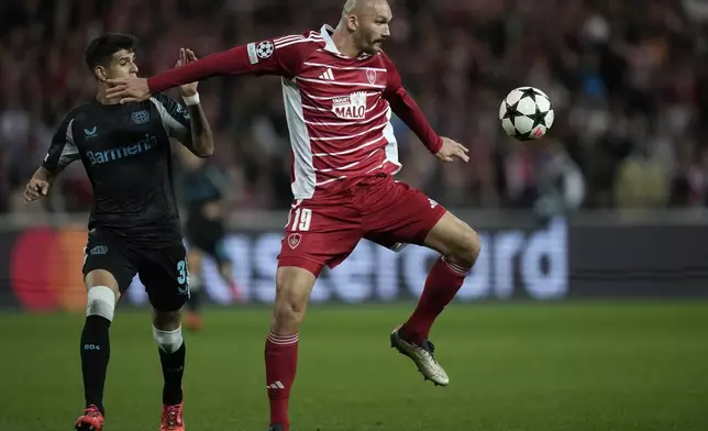 Brest's Ludovic Ajorque receives the ball in front pf Leverkusen's Piero Hincapie during the Champions League opening phase soccer match between Brest and Bayer Leverkusen in Guingamp, western France, Wednesday, Oct. 23, 2024. (AP Photo/Christophe Ena)