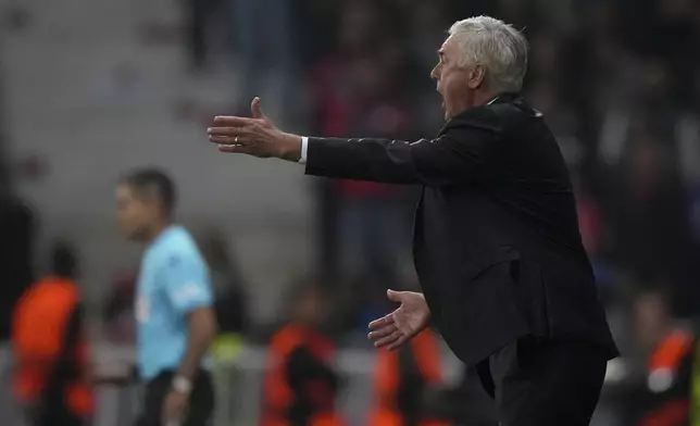 Real Madrid's head coach Carlo Ancelotti protests to referee Maurizio Mariani from Italy during the Champions League opening phase soccer match between Lille and Real Madrid at the Stade Pierre Mauroy in Villeneuve-d'Ascq, outside Lille, France, Wednesday, Oct. 2, 2024. (AP Photo/Thibault Camus)