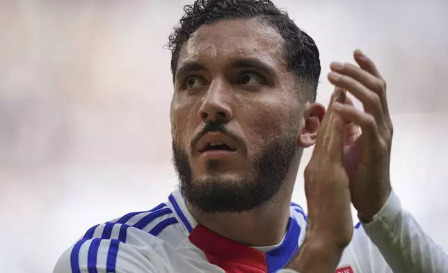 Lyon's Rayan Cherki applauds after being substitute during the French League One soccer match between Lyon and FC Nantes at the Groupama stadium in Decines, outside Lyon, France, Sunday, Oct. 6, 2024. (AP Photo/Laurent Cipriani)