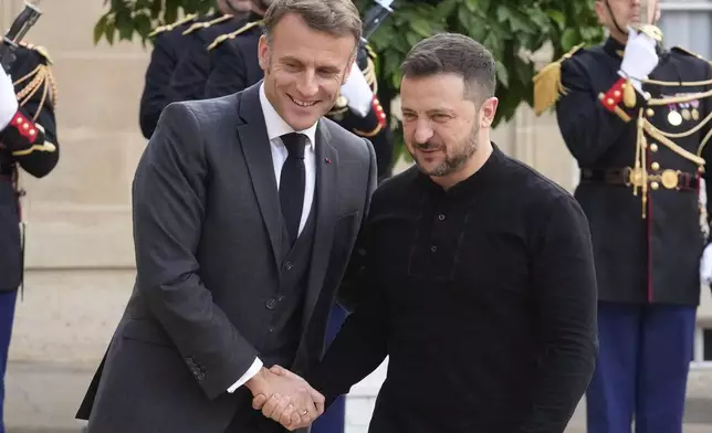 French President Emmanuel Macron, left, welcomes his Ukrainian counterpart Volodymyr Zelenskyy before a meeting at the Elysee Palace, in Paris, Thursday, Oct. 10, 2024. (AP Photo/Michel Euler)