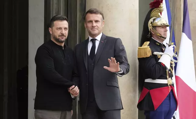 French President Emmanuel Macron, right, welcomes his Ukrainian counterpart Volodymyr Zelenskyy before a meeting at the Elysee Palace, in Paris, Thursday, Oct. 10, 2024. (AP Photo/Michel Euler)