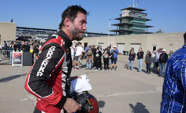 Keanu Reeves walks in the garage area following a GR Cup Series auto race at Indianapolis Motor Speedway, Saturday, Oct. 5, 2024, in Indianapolis. (AP Photo/Darron Cummings)