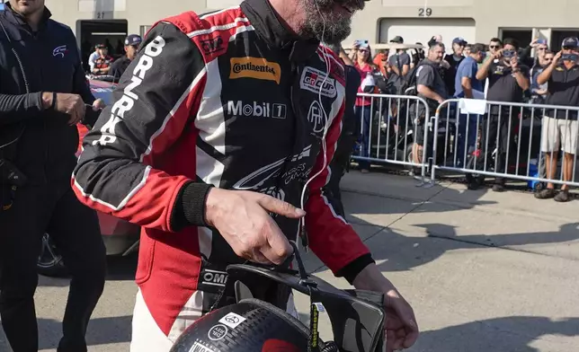 Keanu Reeves walks in the garage area following a GR Cup Series auto race at Indianapolis Motor Speedway, Saturday, Oct. 5, 2024, in Indianapolis. (AP Photo/Darron Cummings)