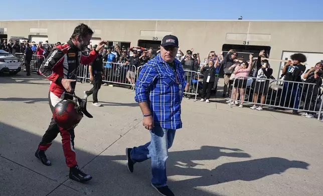 Keanu Reeves waves to fans in the garage area following a GR Cup Series auto race at Indianapolis Motor Speedway, Saturday, Oct. 5, 2024, in Indianapolis. (AP Photo/Darron Cummings)