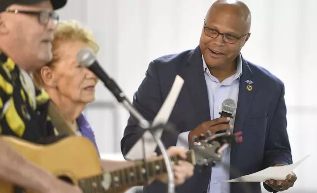 Democratic candidate Shawn Harris, right, sings along with a song written about his campaign during a barbecue at the Chattanooga County Agricultural Center in Summerville, Ga. on Tuesday, Sept. 24, 2024. (Matt Hamilton/Chattanooga Times Free Press via AP)