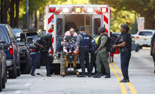 After an hours-long standoff, a suspect is taken into custody with visible injuries on 14th Street outside the Four Seasons Hotel in Midtown in Atlanta, Tuesday, Oct. 29, 2024. (Miguel Martinez/Atlanta Journal-Constitution via AP)