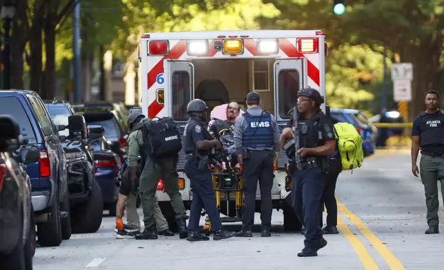 A suspect is taken into custody with visible injuries on 14th Street outside the Four Seasons Hotel where gunshots were re[ported earlier in the Midtown neighborhood of Atlanta, Tuesday, Oct. 29, 2024. (Miguel Martinez/Atlanta Journal-Constitution via AP)